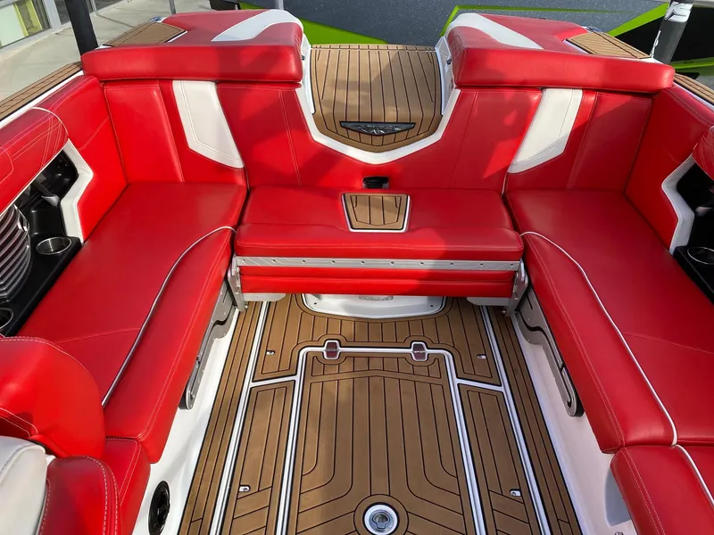 Slide: The Image of 2018 Nautique G23 interior with red seating and teak flooring. - 18