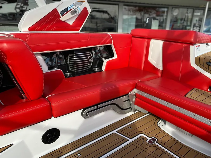 Slide: The Image of 2018 Nautique G23 interior with red and white seating, featuring teak-style flooring. - 19