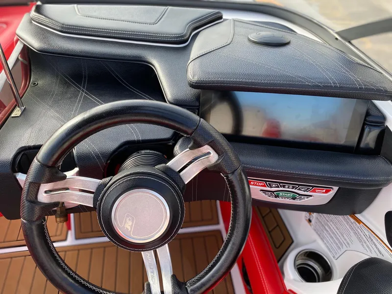 Slide: The Image of 2018 Nautique G23 dashboard with steering wheel and control panel. - 24