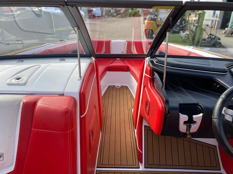 Slide: The Image of 2018 Nautique G23 boat interior with red and white seating, teak flooring, and modern dashboard. - 26