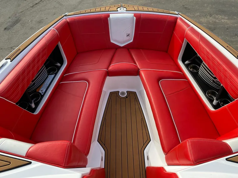 Slide: The Image of 2018 Nautique G23 boat interior with red seating and wood accents. - 27