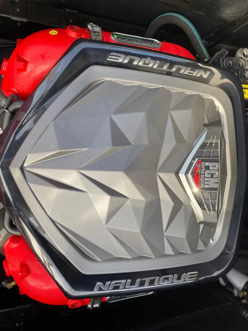 Slide: The Image of 2018 Nautique G23 engine cover with PCM branding, featuring a geometric design. - 36