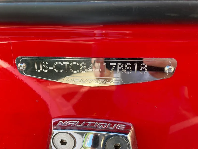 Slide: The Image of 2018 Nautique G23 boat identification plate on red surface. - 38