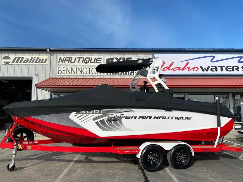 Slide: The Image of 2018 Nautique G23 boat with cover on red trailer, parked outside dealership. - 4