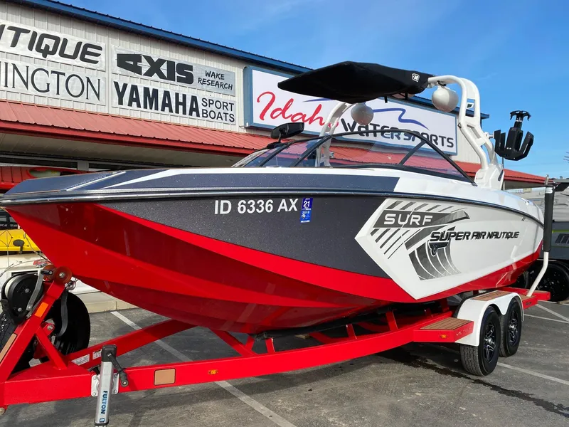 Slide: The Image of 2018 Nautique G23 boat with red hull on trailer at Idaho Water Sports dealership. - 5