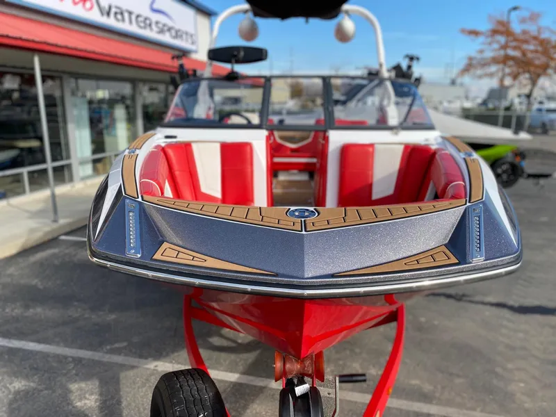 Slide: The Image of 2018 Nautique G23 boat with red and white interior, parked at a dealership. - 7