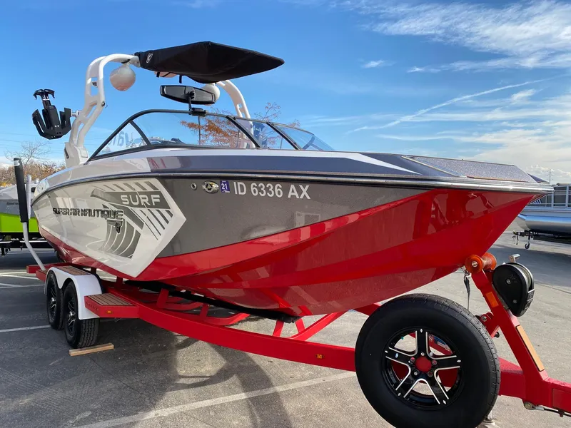 Slide: The Image of 2018 Nautique G23 boat on trailer, red and gray design, parked outdoors. - 8