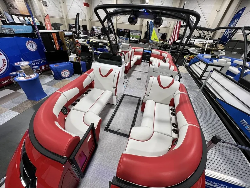 Slide: The Image of 2022 Montara SURF BOSS 23 boat with red and white seating at a boat show. - 11