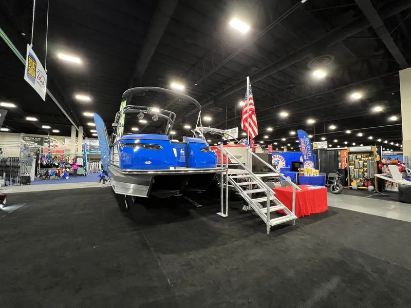 Slide: The Image of 2022 Montara SURF BOSS 23 boat displayed at an indoor exhibition with American flag. - 27