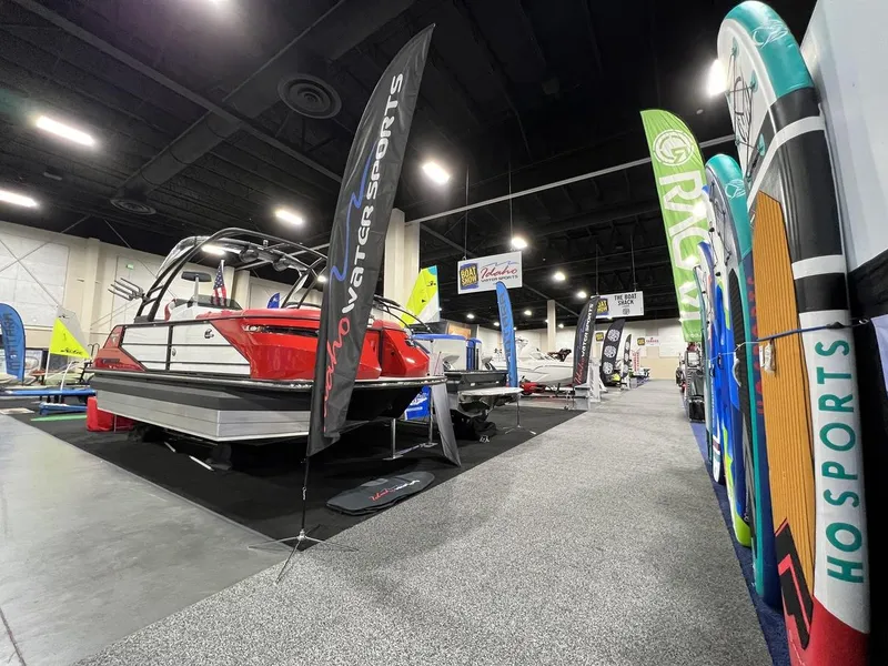 Slide: The Image of 2022 Montara SURF BOSS 23 boat displayed at indoor boat show with colorful banners. - 30