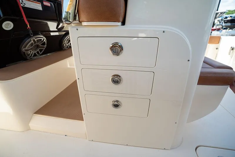 Slide: The Image of 2025 Scout 330 LXF boat interior with storage drawers and seating. - 13