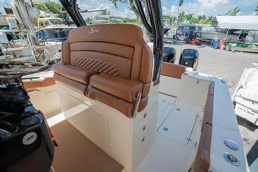 Slide: The Image of 2025 Scout 330 LXF boat interior with brown leather seating and modern design. - 14