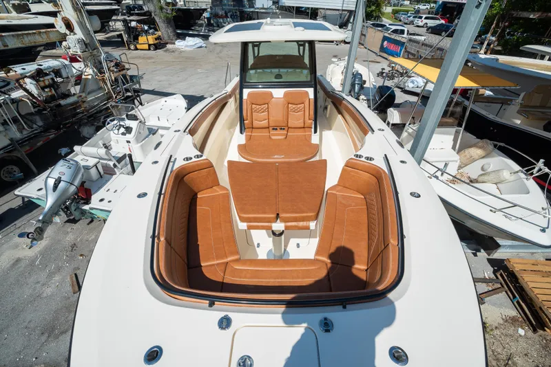 Slide: The Image of 2025 Scout 330 LXF boat with luxurious tan seating in a marina. - 17