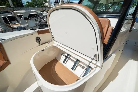 Slide: The Image of 2025 Scout 330 LXF boat with open storage compartment. - 20