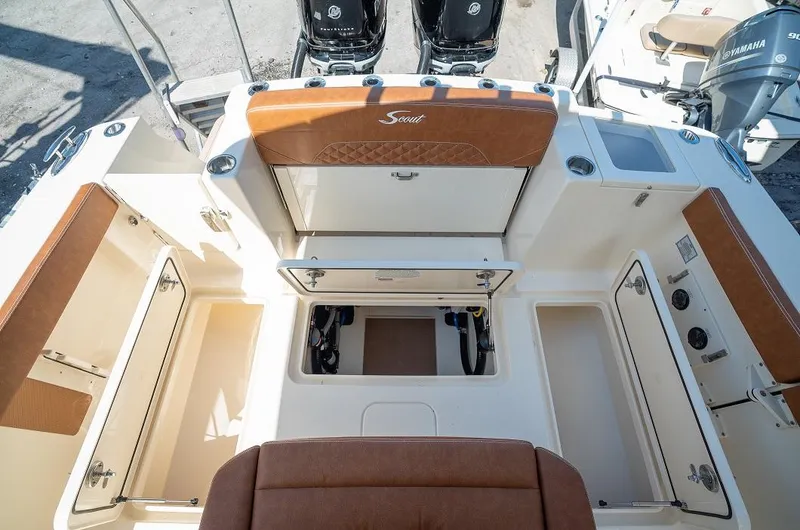 Slide: The Image of 2025 Scout 330 LXF boat interior with storage compartments and twin outboard engines. - 23