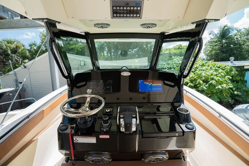 Slide: The Image of 2025 Scout 330 LXF boat helm with advanced navigation system and steering wheel. - 24