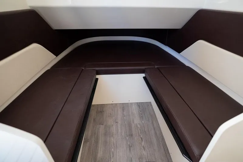 Slide: The Image of 2025 Scout 330 LXF cabin interior with brown seating and wood flooring. - 29