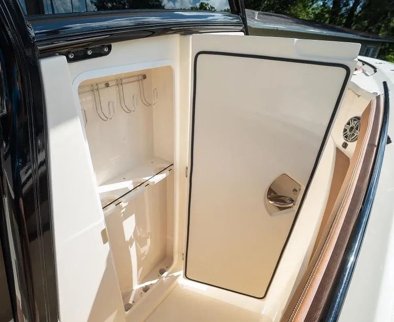 Slide: The Image of 2025 Scout 330 LXF boat storage compartment with hooks and shelves. - 41
