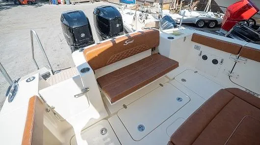 Slide: The Image of 2025 Scout 330 LXF boat interior with brown leather seats and dual outboard engines. - 6