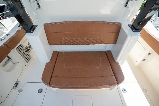 Slide: The Image of 2025 Scout 330 LXF boat with brown cushioned seating. - 8