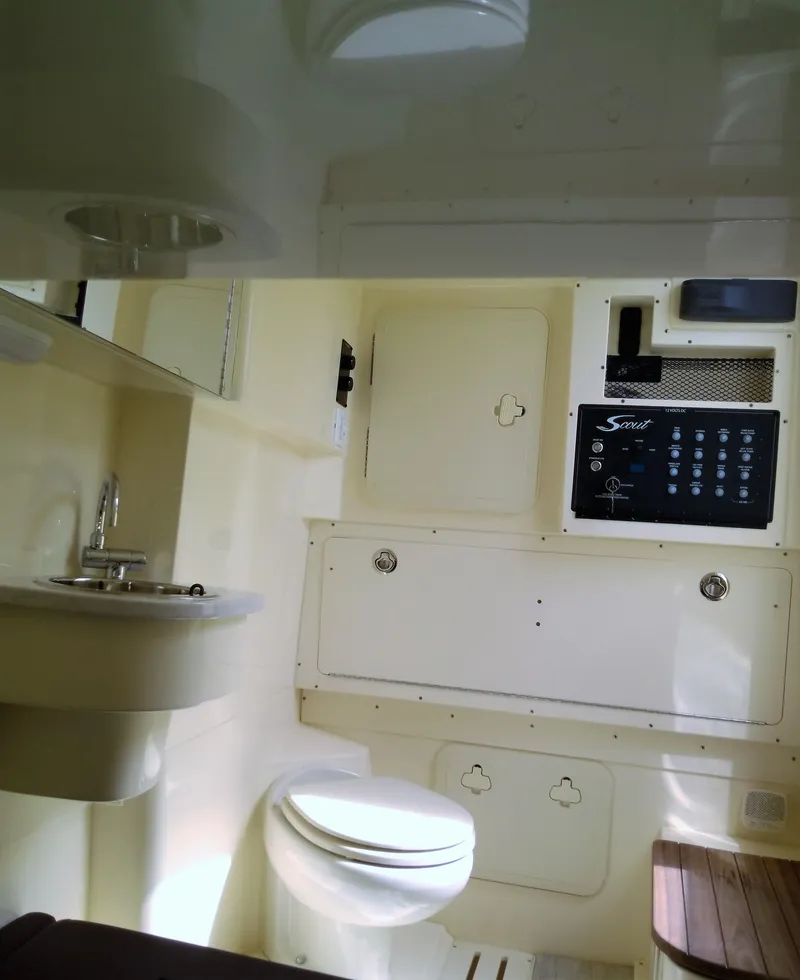 Slide: The Image of 2025 Scout 305 LXF boat interior with toilet, sink, and control panel. - 11