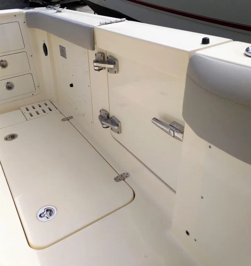 Slide: The Image of 2025 Scout 305 LXF boat interior, featuring storage compartments and stainless steel hardware. - 13