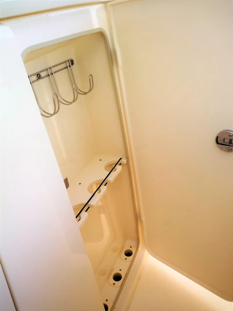 Slide: The Image of 2025 Scout 305 LXF boat storage compartment with hooks and holders. - 16