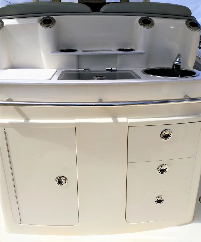 Slide: The Image of 2025 Scout 305 LXF boat interior with sink, storage cabinets, and drawers. - 19