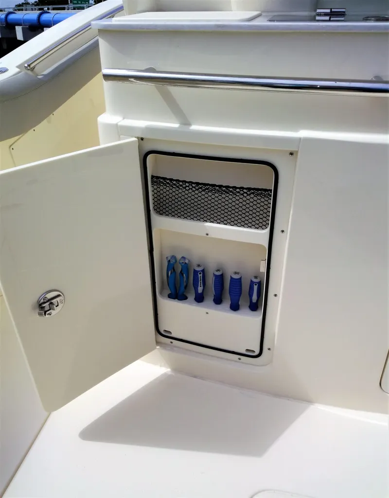 Slide: The Image of Storage compartment with tools on a 2025 Scout 305 LXF boat. - 20
