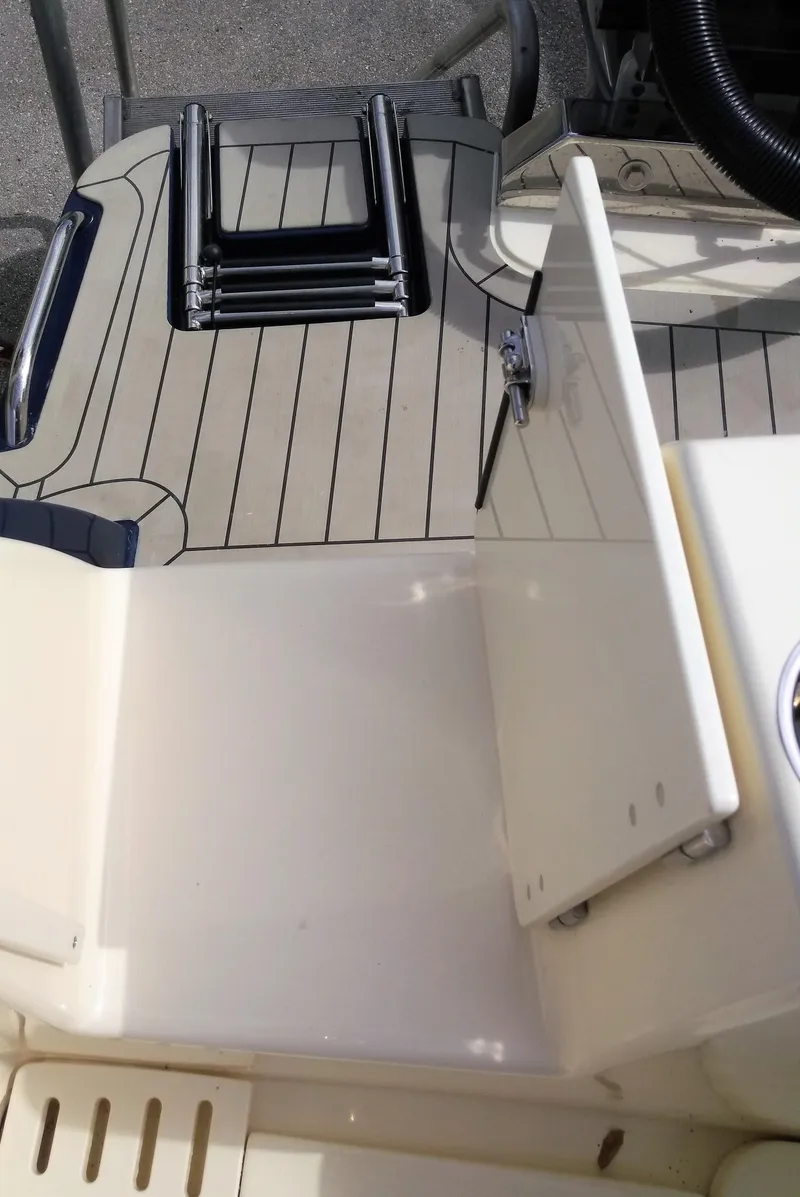 Slide: The Image of 2025 Scout 305 LXF boat deck with foldable ladder and storage compartment. - 21