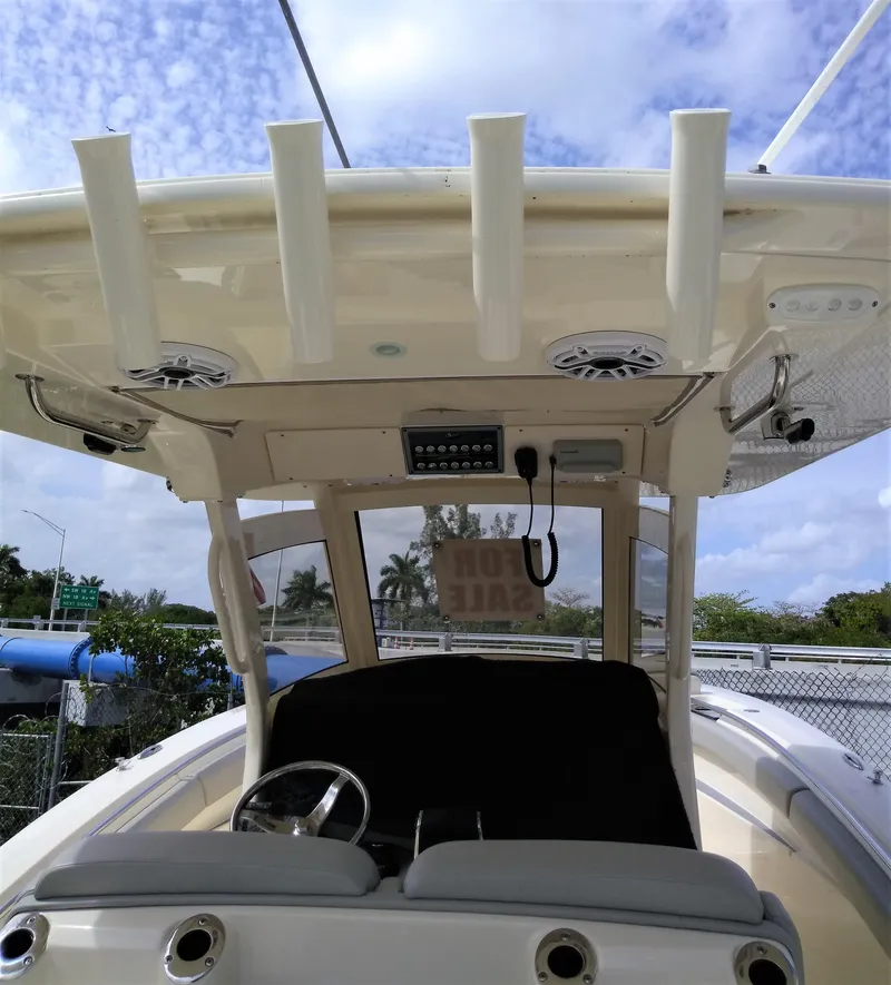 Slide: The Image of 2025 Scout 305 LXF boat interior with steering wheel and rod holders. - 23