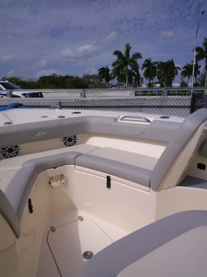 Slide: The Image of 2025 Scout 305 LXF boat interior with cushioned seating and palm trees in the background. - 5