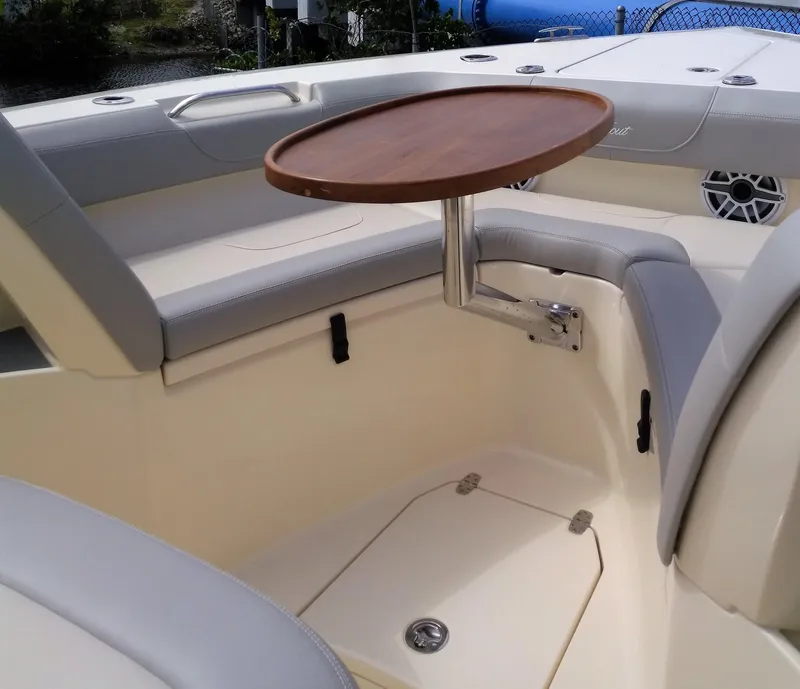 Slide: The Image of 2025 Scout 305 LXF boat interior with seating and wooden table. - 9