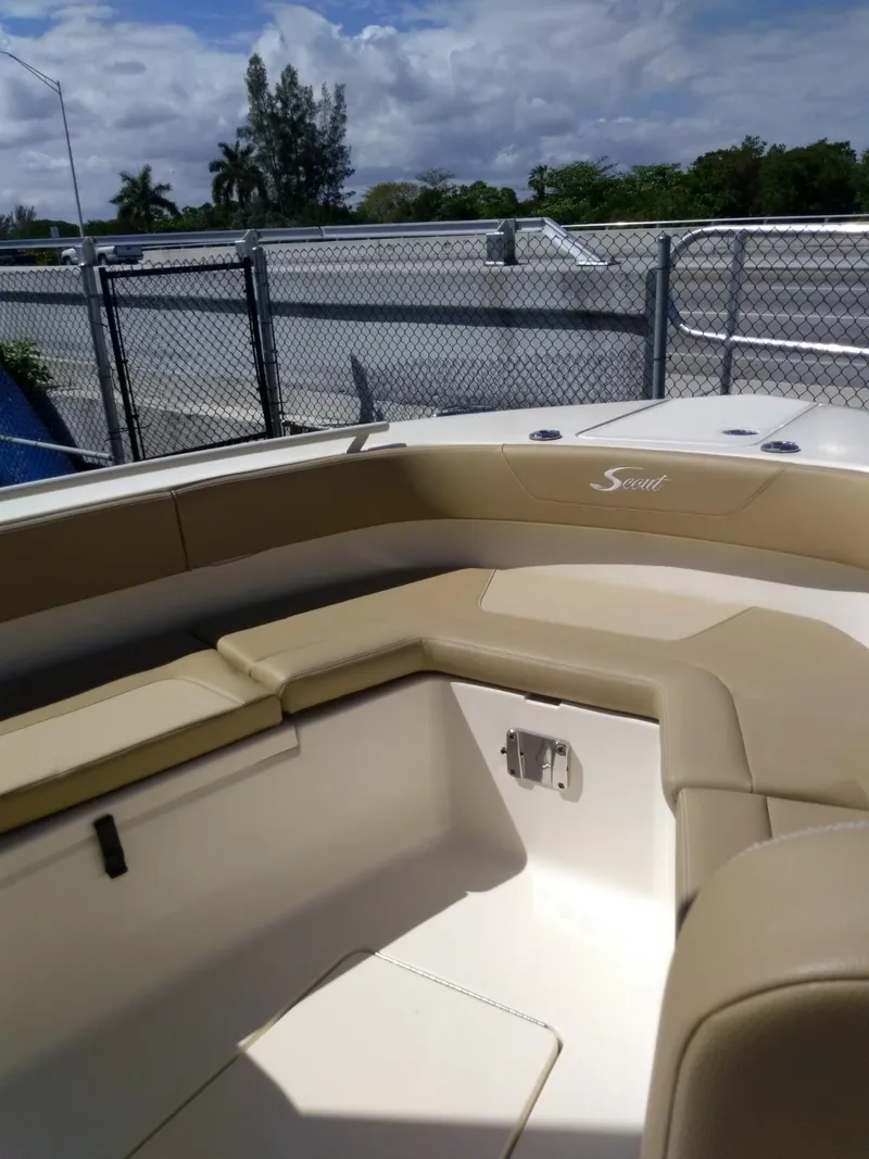 Slide: The Image of 2025 Scout 277 LXF boat interior with beige seating and white deck. - 13