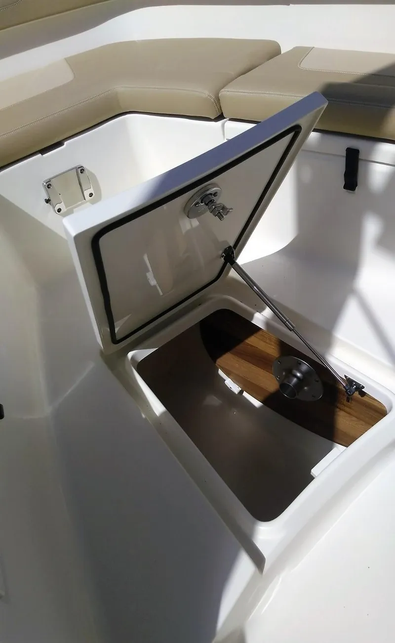Slide: The Image of 2025 Scout 277 LXF boat storage compartment with open hatch and cushioned seating. - 16
