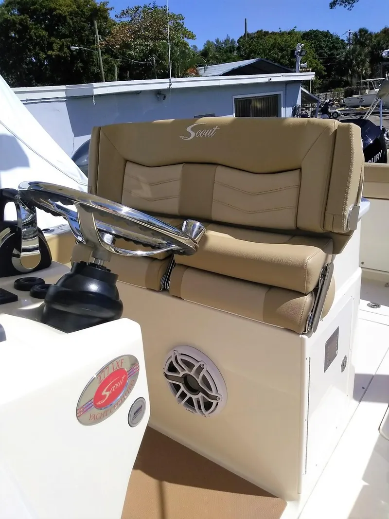 Slide: The Image of 2025 Scout 277 LXF boat helm with tan seating and steering wheel. - 5