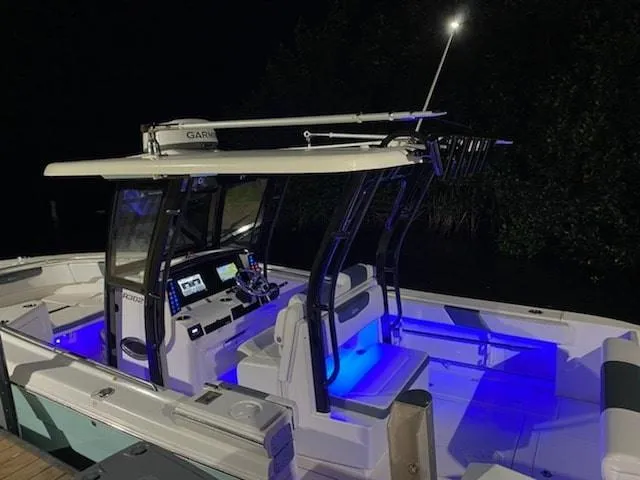 Slide: The Image of 2020 Robalo 302 boat with blue LED lights at night. - 2