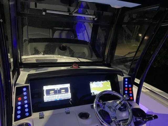 Slide: The Image of 2020 Robalo 302 boat dashboard with dual screens and illuminated controls at night. - 7