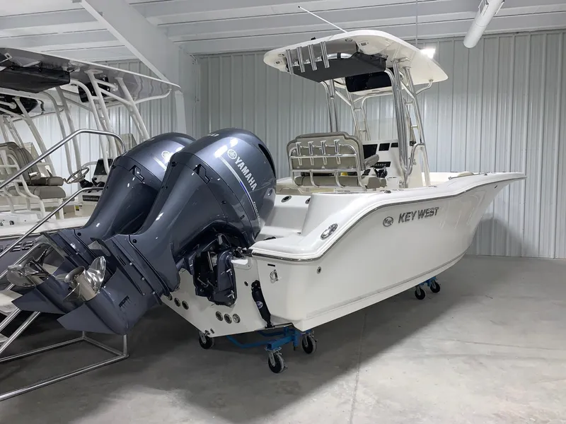 Slide: The Image of 2024 Key West 244 Center Console boat with twin Yamaha engines in a showroom. - 2
