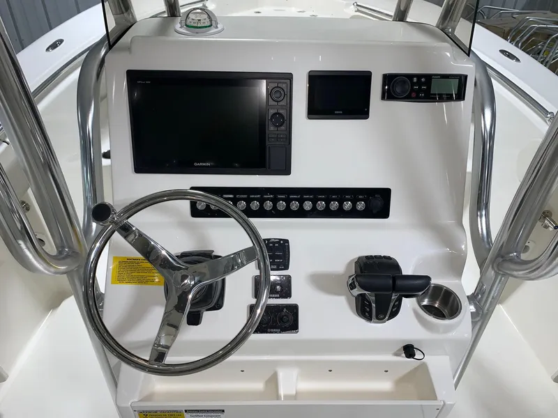 Slide: The Image of 2024 Key West 244 Center Console boat dashboard with steering wheel and electronic controls. - 6