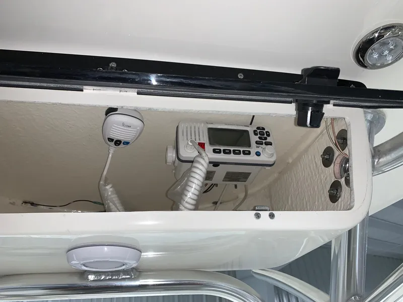 Slide: The Image of 2024 Key West 244 Center Console boat electronics compartment with radio and controls. - 7