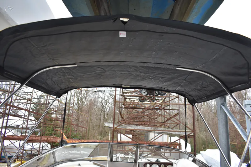 Slide: The Image of 2005 Regal Commodore 2665 boat with black canopy under a bridge. - 10