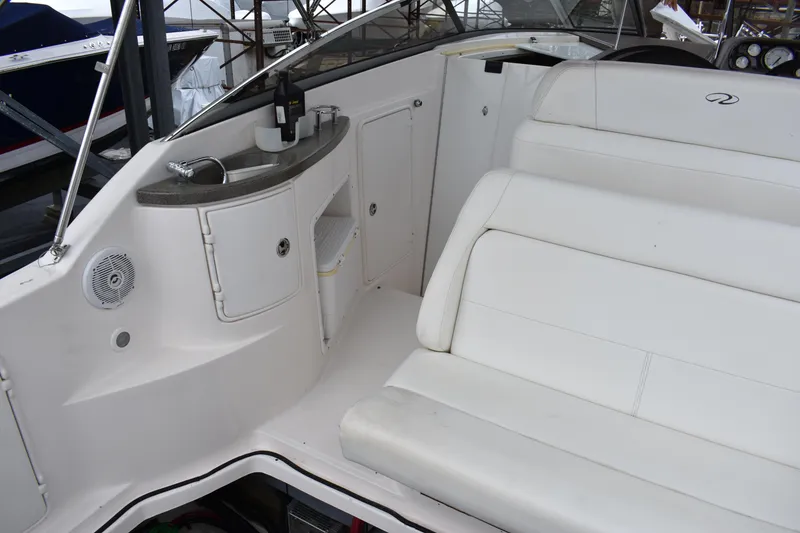 Slide: The Image of 2005 Regal Commodore 2665 boat interior with white seating and built-in beverage station. - 12