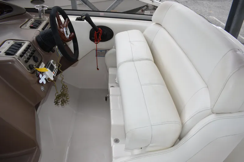 Slide: The Image of 2005 Regal Commodore 2665 boat interior with white seating and steering wheel. - 18