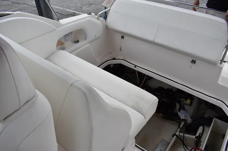 Slide: The Image of 2005 Regal Commodore 2665 boat interior with white seating and open engine compartment. - 19