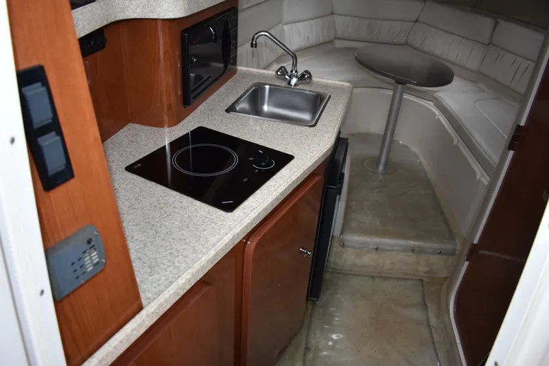 Slide: The Image of 2005 Regal Commodore 2665 boat interior with kitchenette and seating area. - 28