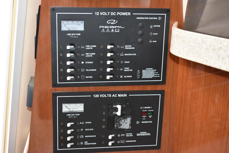 Slide: The Image of Electrical control panel on 2005 Regal Commodore 2665 boat, featuring 12V DC and 120V AC systems. - 32