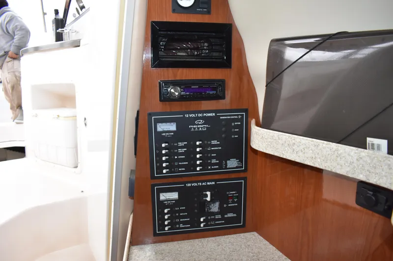 Slide: The Image of Control panel of a 2005 Regal Commodore 2665 boat interior, featuring switches and audio system. - 33