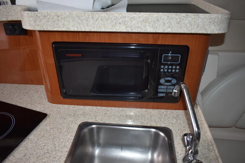 Slide: The Image of 2005 Regal Commodore 2665 kitchen area with microwave, sink, and countertop. - 34