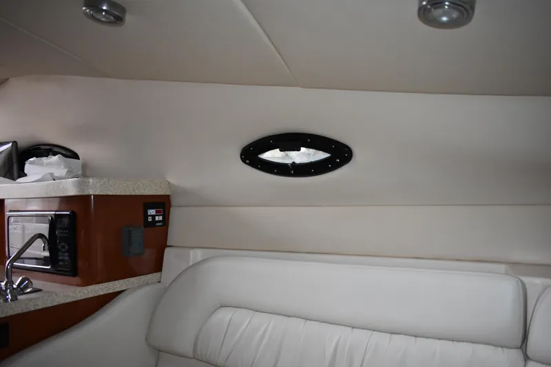 Slide: The Image of Interior of 2005 Regal Commodore 2665 boat with white seating and kitchenette. - 45